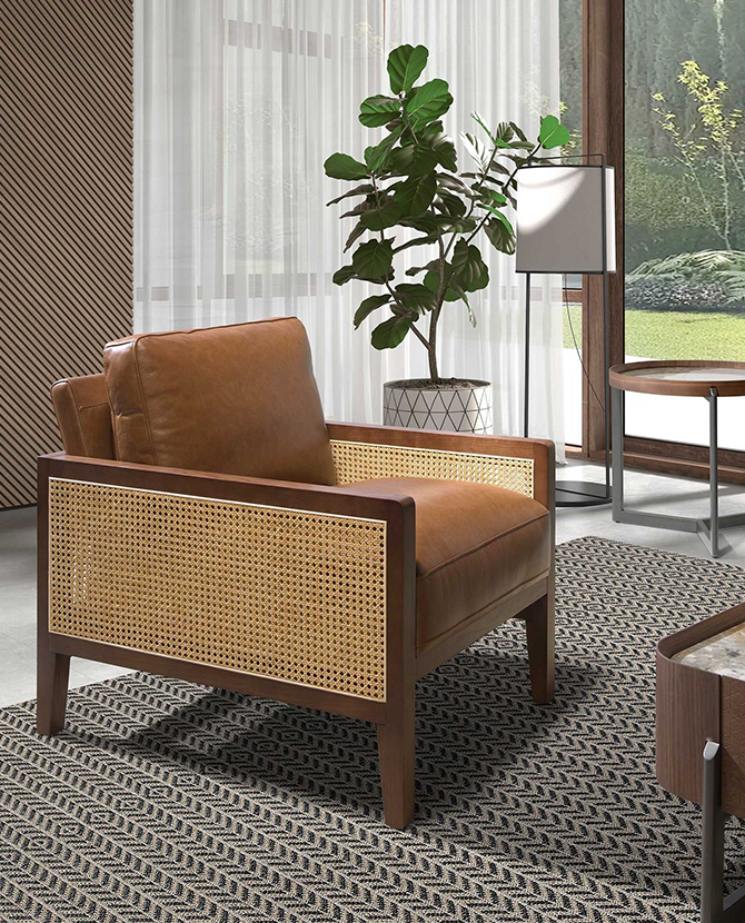 Konyakbarna színű marhabőrrel kárpitozott, rattanbetétes design fotel.