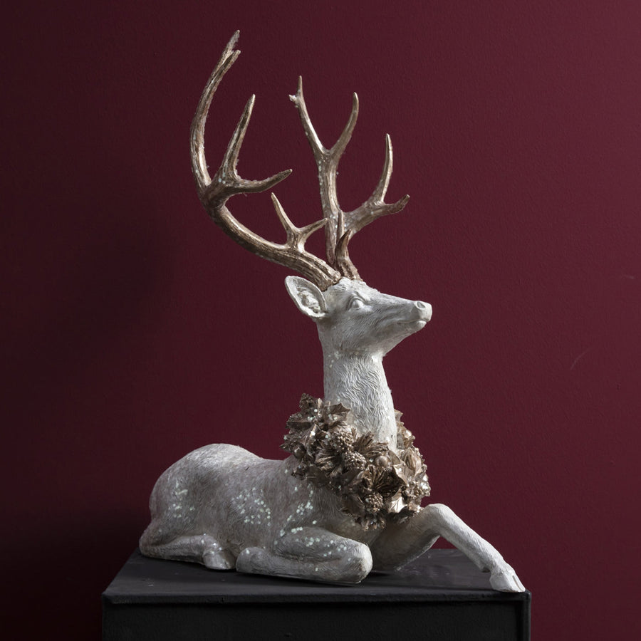 Pezsgőszínű tobozkoszorúval díszített fehér szarvas részletfotó