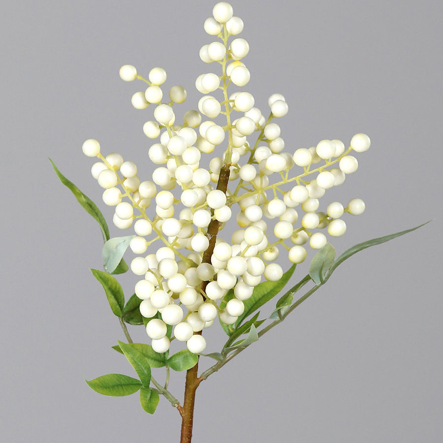 Dekoratív mű hóbogyó ág krémszínű bogyókkal közelről