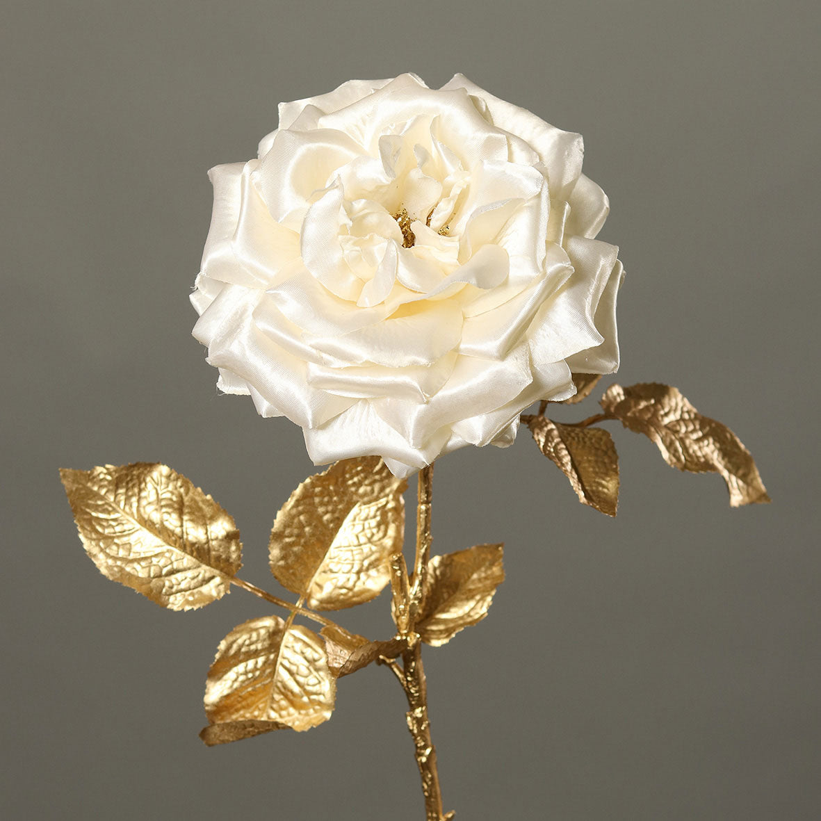 Fényes aranyszínű szárú és levelű, krém színárnyalatú szatén rózsa művirág.