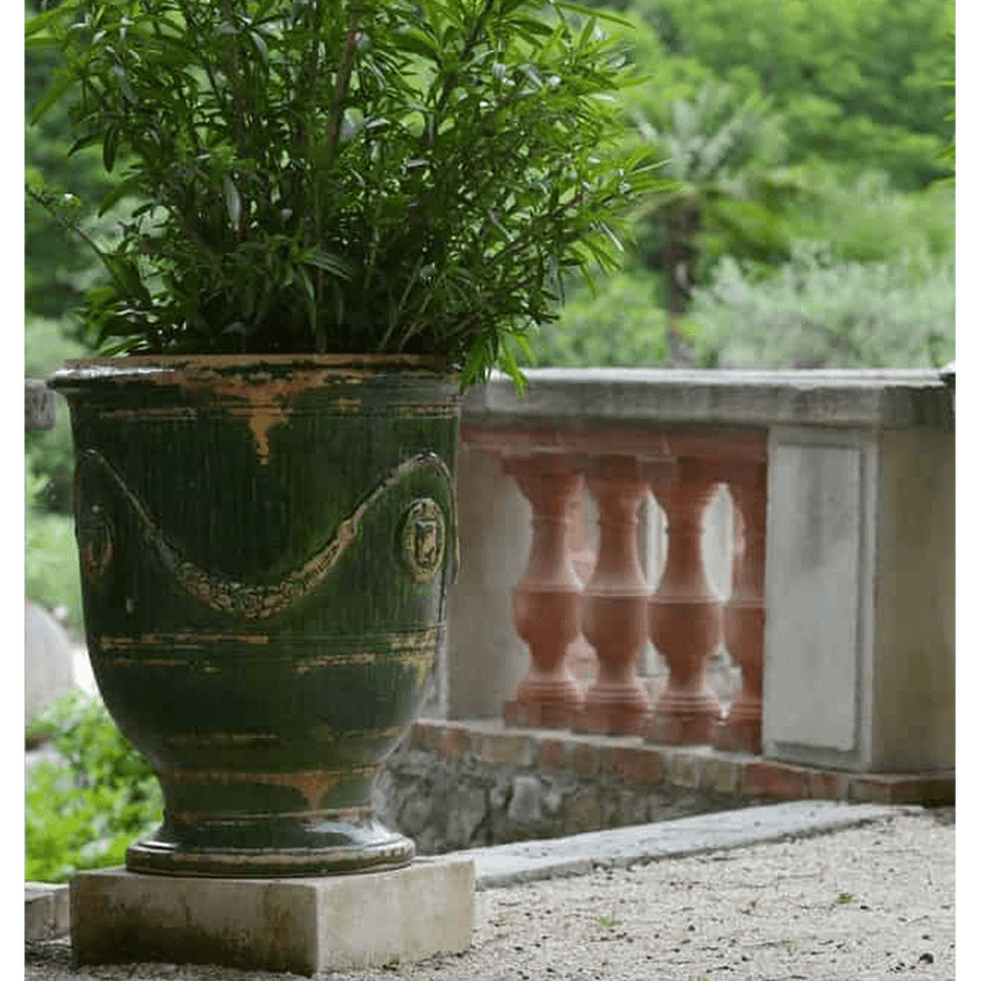 ANtikolt zöld színű mázas anduze kaspó leanderrel, klasszikus balkonon. 