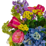 Vegyes művirágokból készült nagy virágcsokor, áttetsző üvegvázában.