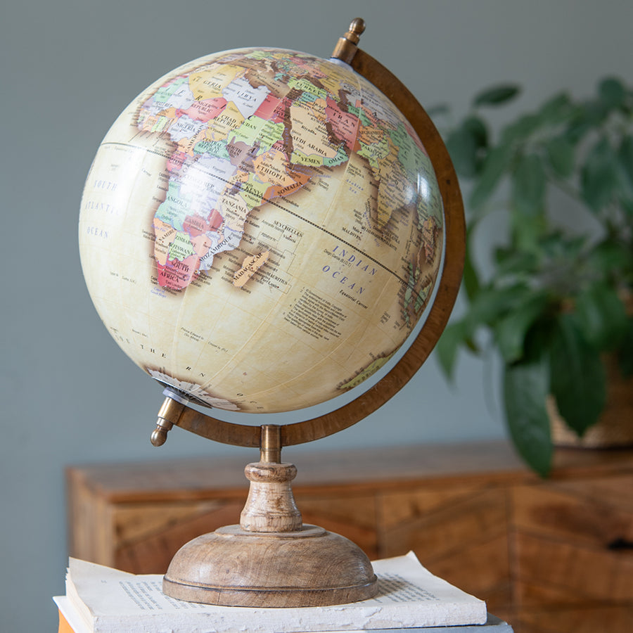 Antik sárga alapszínű, vintage stílusú dekor földgömb, mangófa talapzaton.