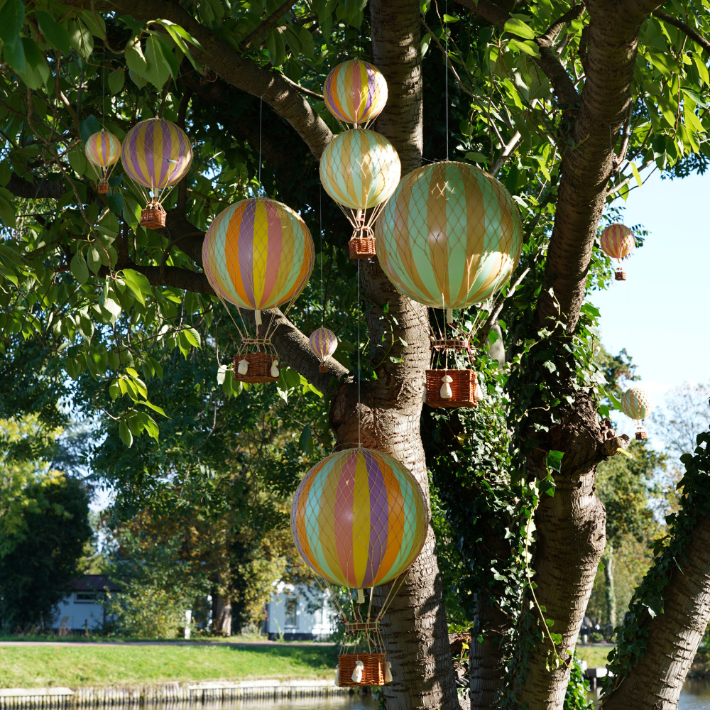 Kerthelység fáról lógó vintage hőlégballonokkal.