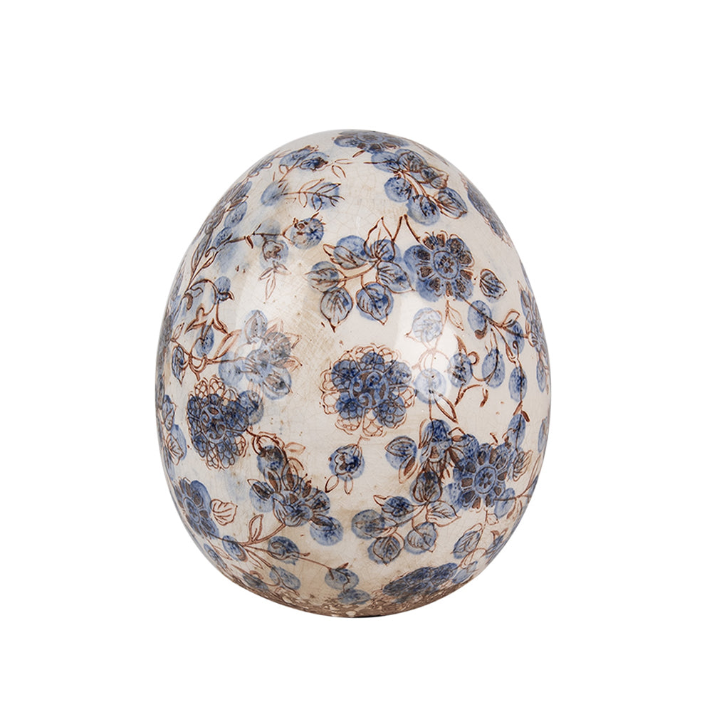 Kék színű növényi motívummal díszített kerámia tojás.