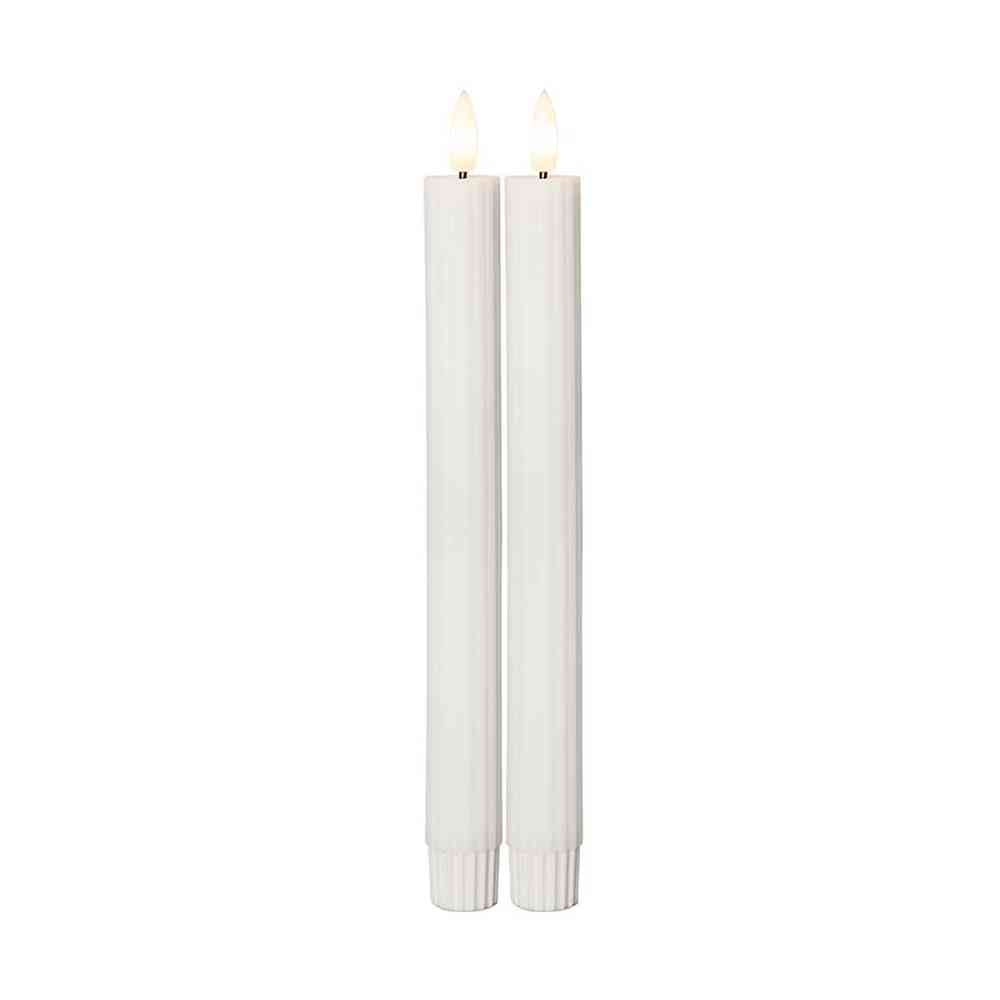 Két darab 25 cm magas, fehér LED vacsoragyertya valódi viaszból, kannelúrás felülettel, meleg fényű pislákoló lánggal, fehér háttérrel.