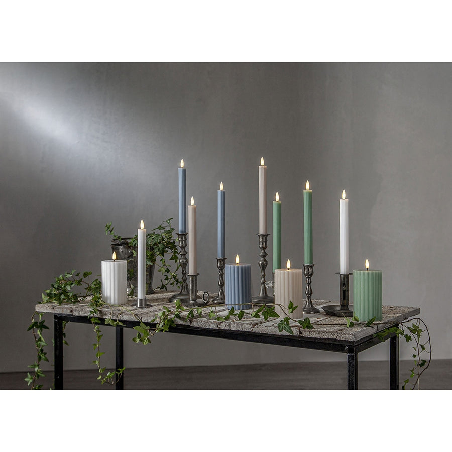 Stripe LED gyertya kollekció különböző méretű és színű valódi viaszból készült kannelúrás gyertyákkal, vintage gyertyatartókban elhelyezve, meleg fényű LED lánggal.