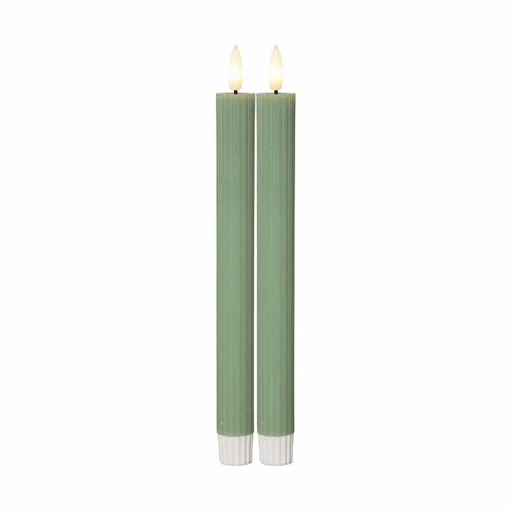 Két darab 25 cm magas, zöld LED vacsoragyertya valódi viaszból, kannelúrás felülettel, meleg fényű pislákoló lánggal, fehér háttérrel.