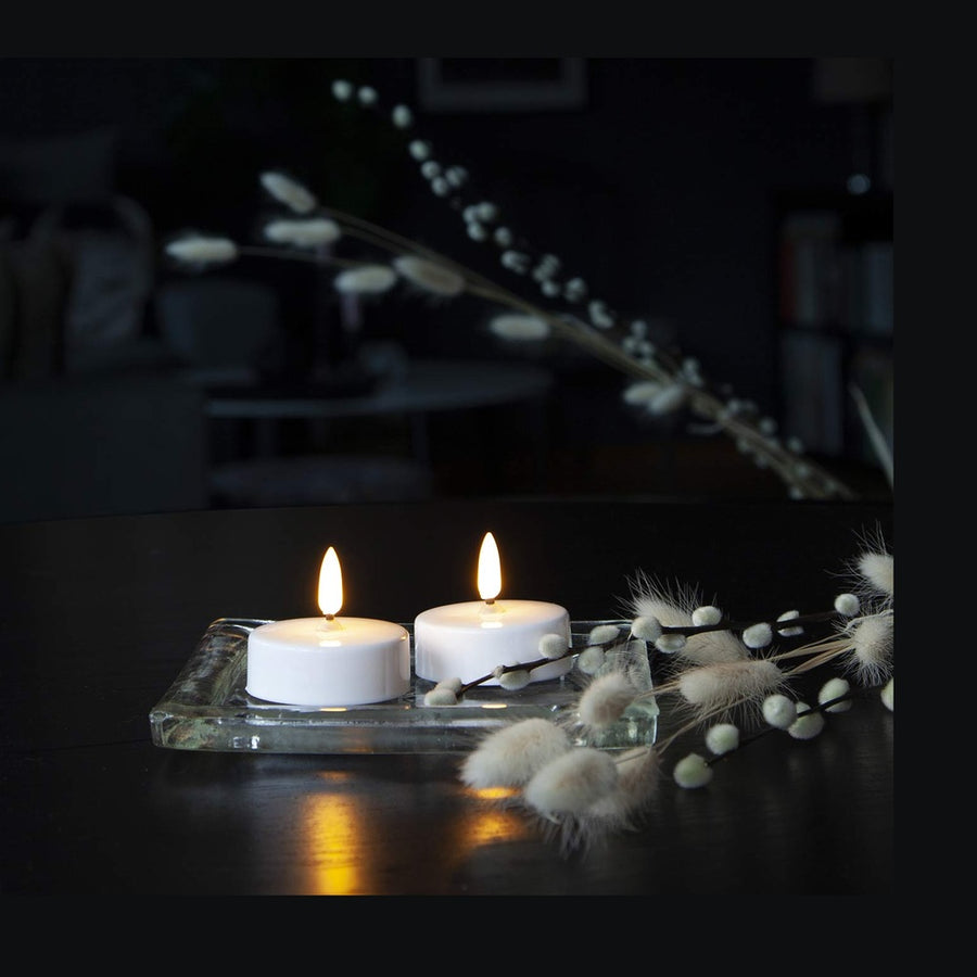 2 darab LED-es teamécses sötét asztalon.