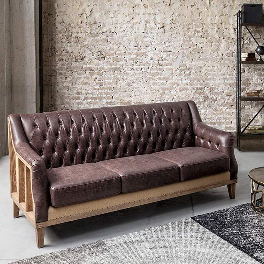 Loft stílusú, sötétbarna bőrrel kárpitozott kőrisfa kanapé.