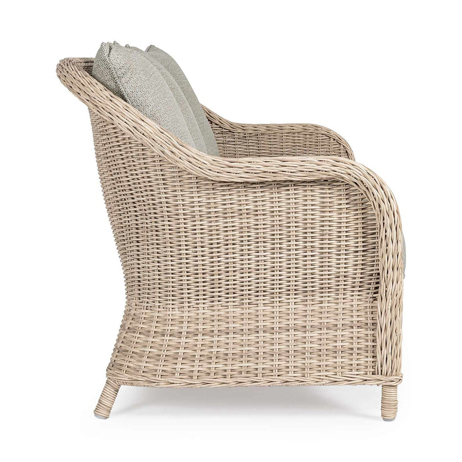 Vidéki vintage stílusú, háromszemélyes, natúr színű műrattan kerti kanapé, bézs színű olefin ülő és hátpárnával.