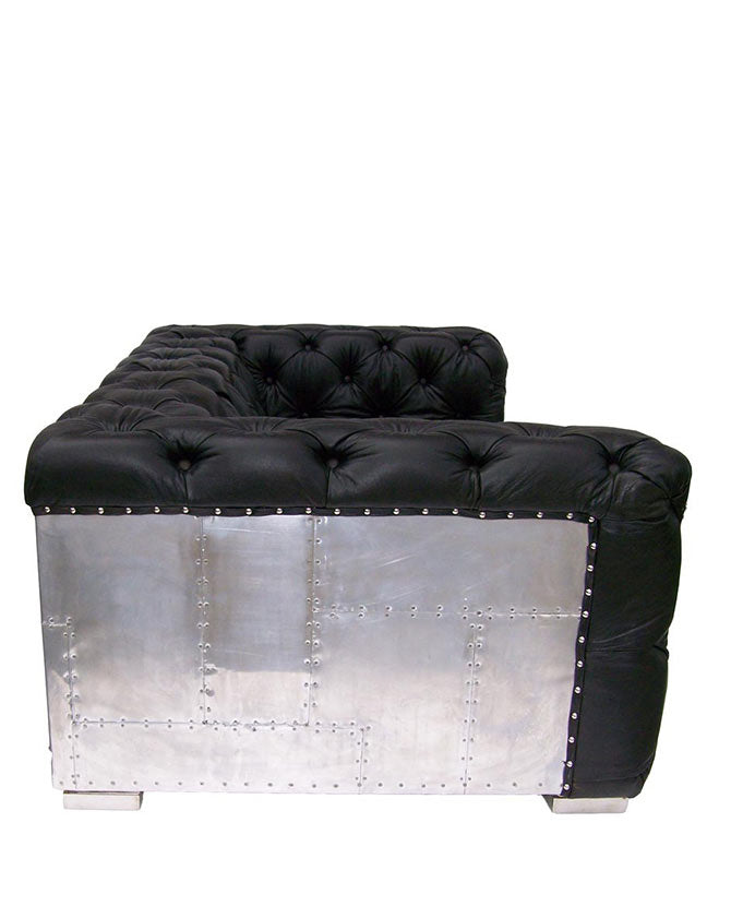 Kortárs stílusú, fekete bőr kanapé szegecselt alumínium burkolattal.