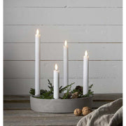 4 különböző méretű szálas lled gyertya fém gyertyatartóban, fehér színű deszka fal előtt Élethű megjelenésű, eltérő magasságú LED gyertyák valódi viasz testtel.