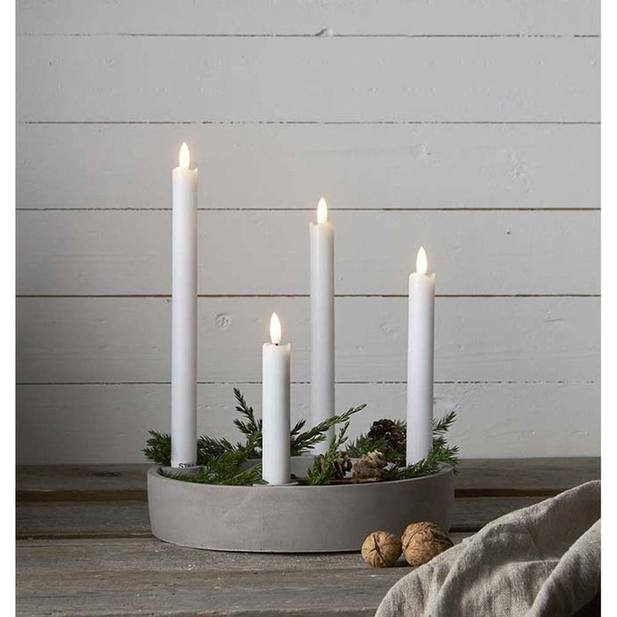 4 különböző méretű szálas lled gyertya fém gyertyatartóban, fehér színű deszka fal előtt Élethű megjelenésű, eltérő magasságú LED gyertyák valódi viasz testtel.