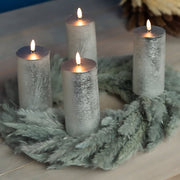 Ezüstszínű LED gyertyák fenyőkoszorún.