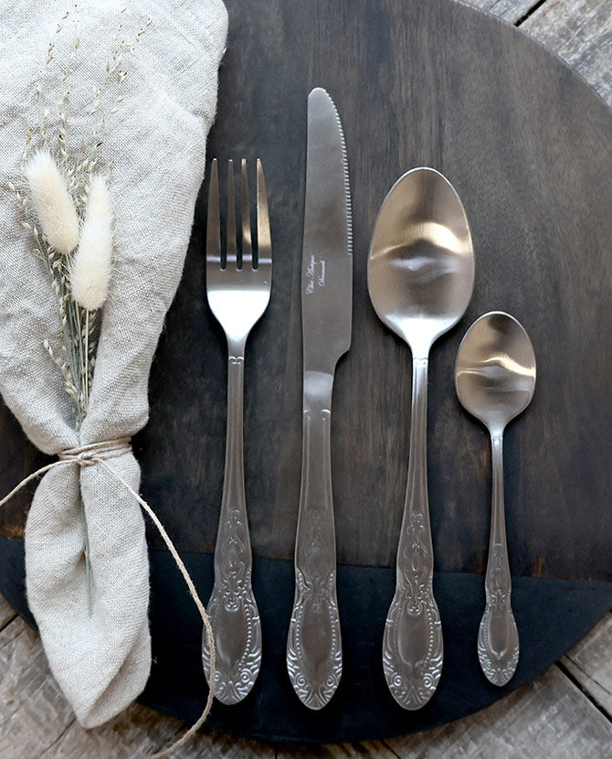 Ezüst színű, vintage stílusú, rozsdamentes acélból készült négydarabos evőeszközkészlet.