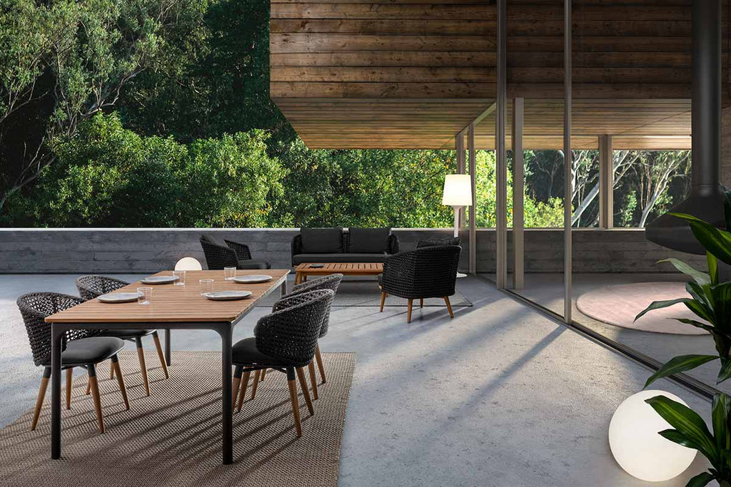 Modern teraszon álló étkezőasztal, kortárs stílusú, formatervezett kerti étkezőszékekkel.
