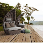 Medence szélén álló, egymástól elválasztott kerti pihenőágy.