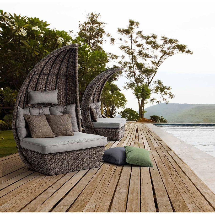 Medence szélén álló, egymástól elválasztott kerti pihenőágy.