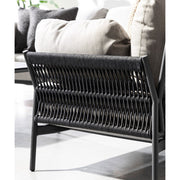 Napsütötte teraszon álló, kortárs stílusú, fekete és világosszürke kültéri fotel részlete.