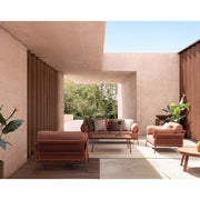 Fedett, mediterrán teraszon álló kortárs, korallszínű kanapé és fotelek és dohányzóasztal.