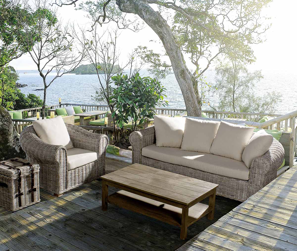 Tengerparti teraszon álló mediterrán stílusú rattanfotel és kanapé.