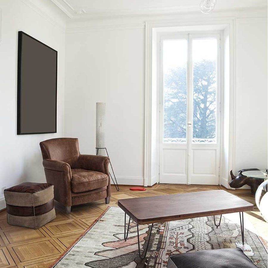 Loft stílusú nappali bőrfotellel és bőrből készült puffal.