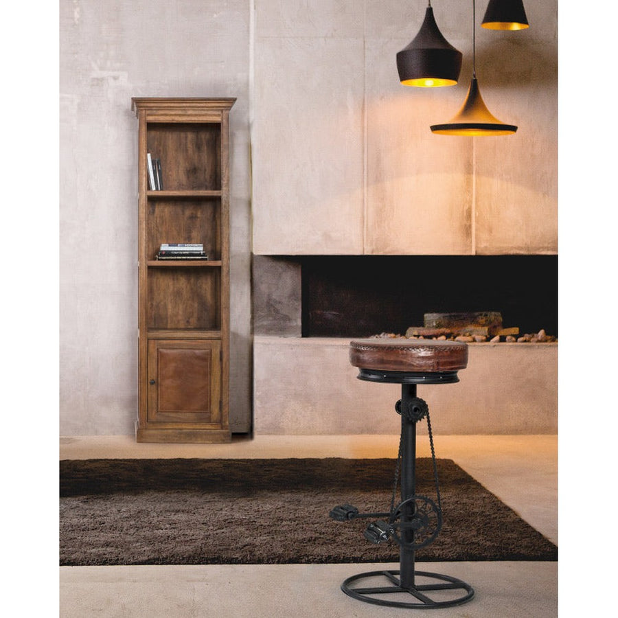 Loft stílusú szobabelső kandalóval, ipari függesztékekkel, könyvespolccal és ipari stílusú pedálos bárszékkel.