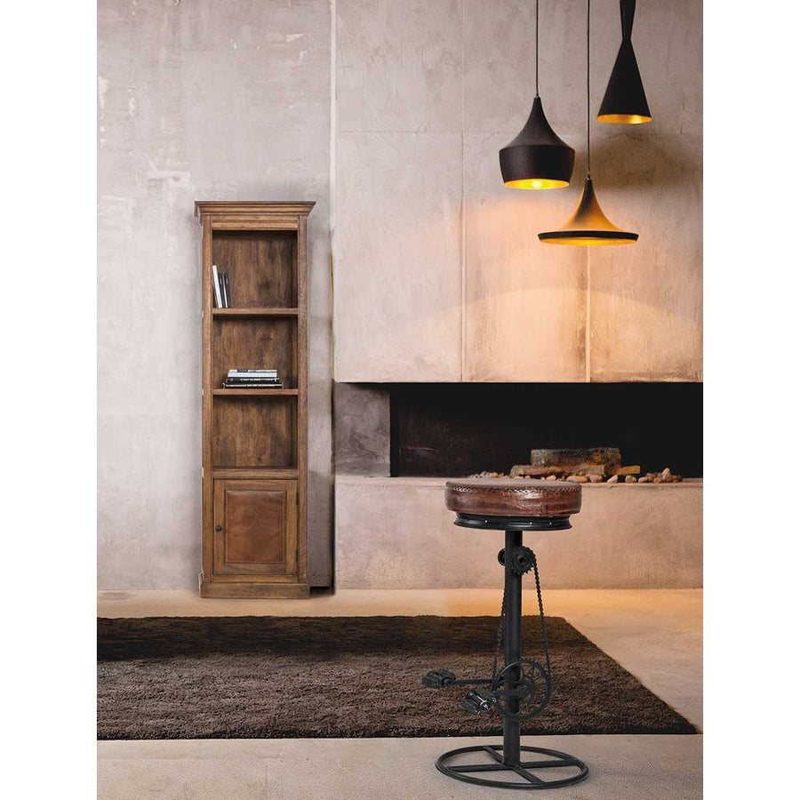 Loft stílusú szobabelső kandalóval, ipari függesztékekkel, könyvespolccal és ipari stílusú pedálos bárszékkel.