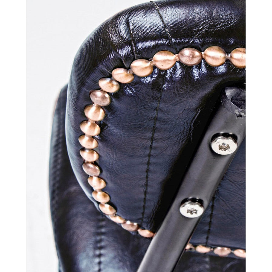 Vintage stílusú bárszék sötétkék műbőr háttámlájának aranyszeges díszítése.