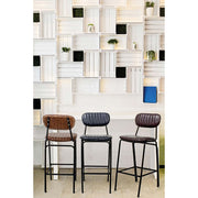 Loft stílusú bár, fehér ládafallal és három drab vintage stílusú bárszékkel.