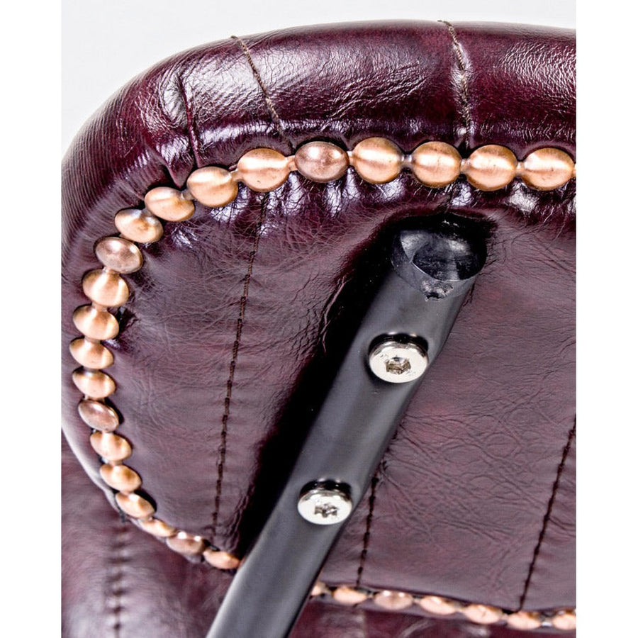 Vintage stílusú bárszék bordó műbőr háttámlájának aranyszeges díszítése.