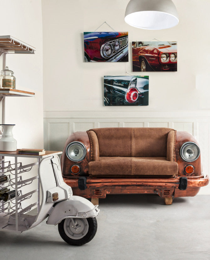 Loft stílusú nappaliban felállított bronz színű autófront kanapé, bőr üléssel és működő autólámpákkal.