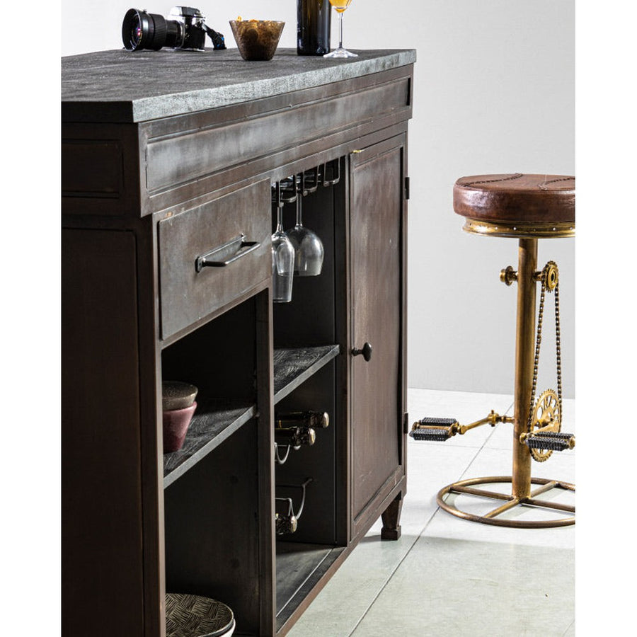 Fából készült bárpult mellett álló ipari stílusú pedálos bárszék.