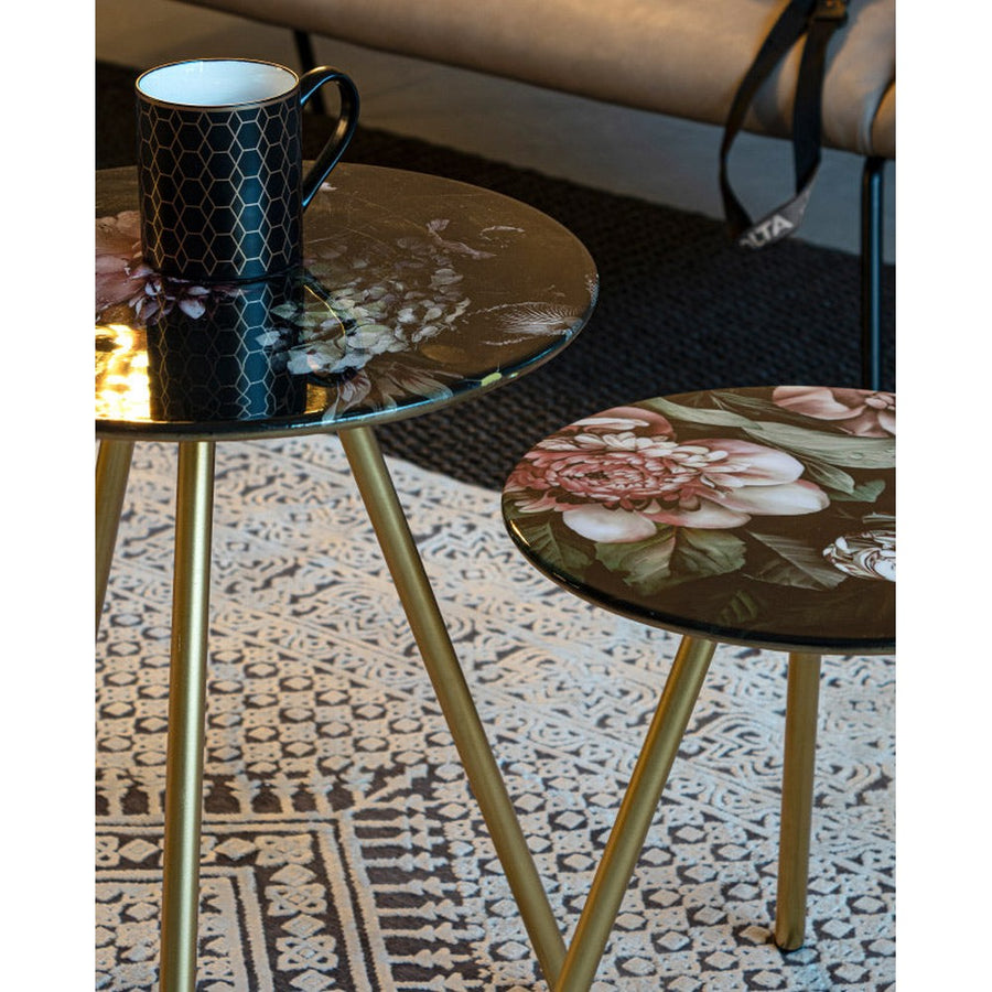 Acélból készült kisasztal arany színű lábakkal és virágmintás zománcfestéssel a fedlapján.