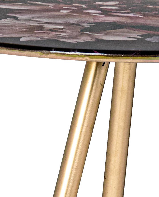 Acélból készült kisasztal arany színű lábakkal és virágmintás zománcfestéssel a fedlapján.