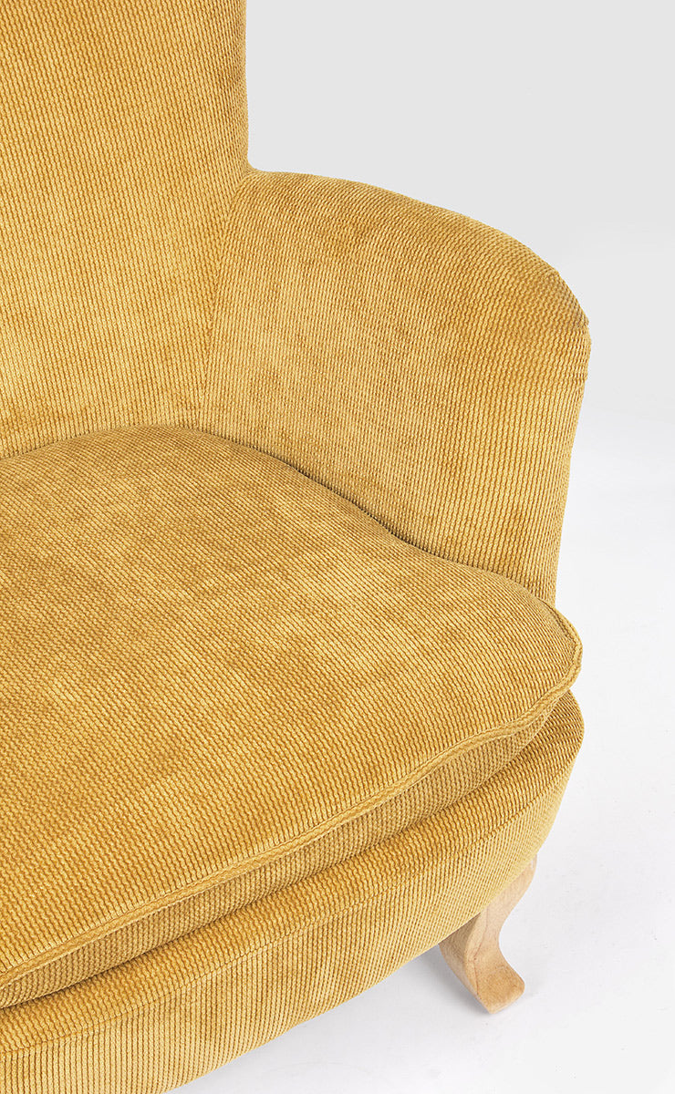 A retró stílusú, okkersárga színű fotel ülőpárna és karfa részlete.