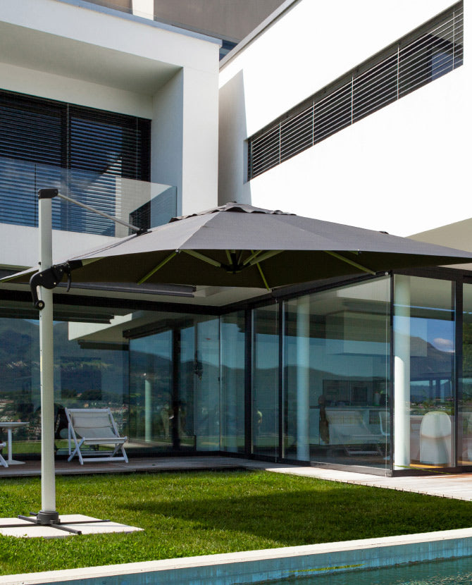 Modern stílusú épület előtt álló fémvázas szövet napernyő.