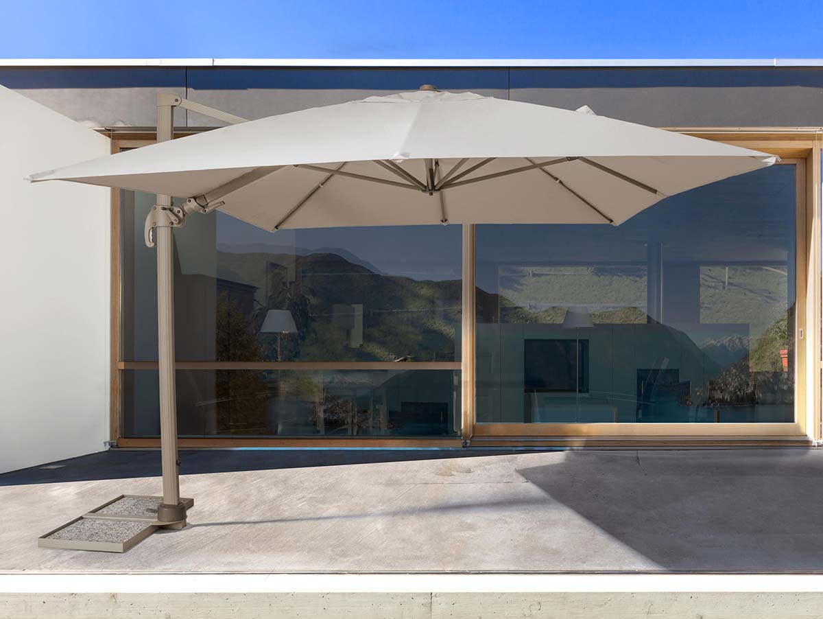 Modern ház előtti teraszon álló fémvázas napernyő.