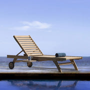Medence szélén álló napozóágy.