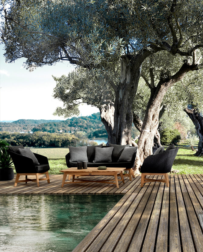 Medence partján, olajfa alatt álló négyrészes kortárs design kerti ülőgarnitúra.