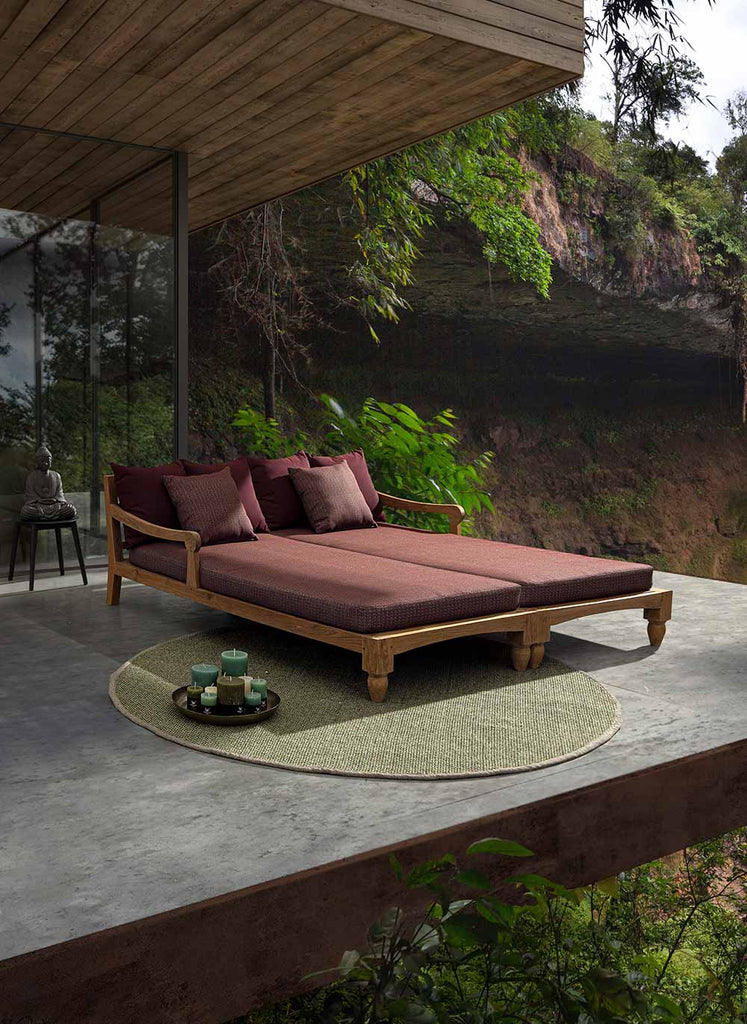 Keleti stílusú, teakfa pihenőágy, bordó színű párnákkal erdei teraszon. 