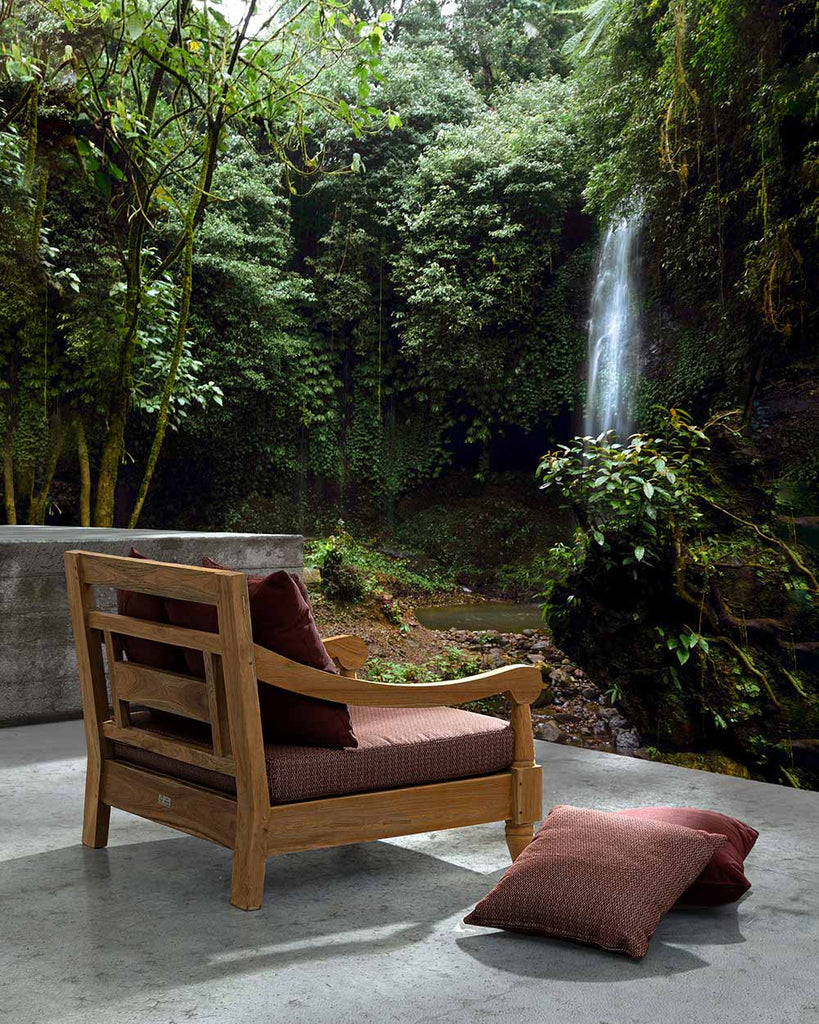 Keleti stílusú teakfa kerti fotel, bordó párnákkal erdei teraszon.