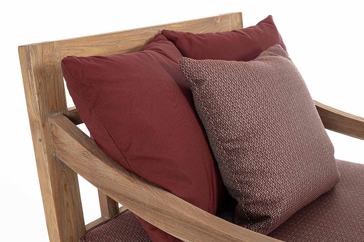 Keleti stílusú teakfa fotel részlete a bordó színű párnákkal.