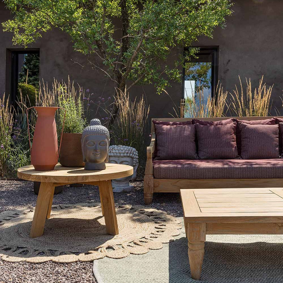 Mediterrán udvaron álló bordó színű teakfa Bali kanapé és dohányzóasztal.