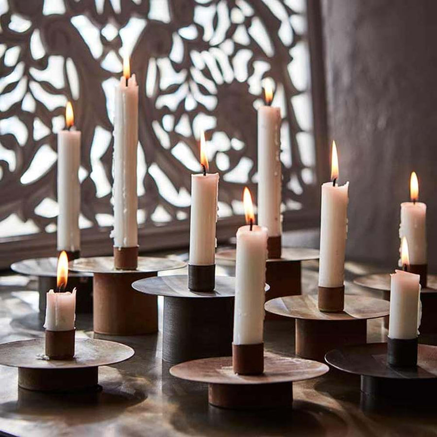Égő gyertyák vintage stílusú henger alakú gyertyatartókon.