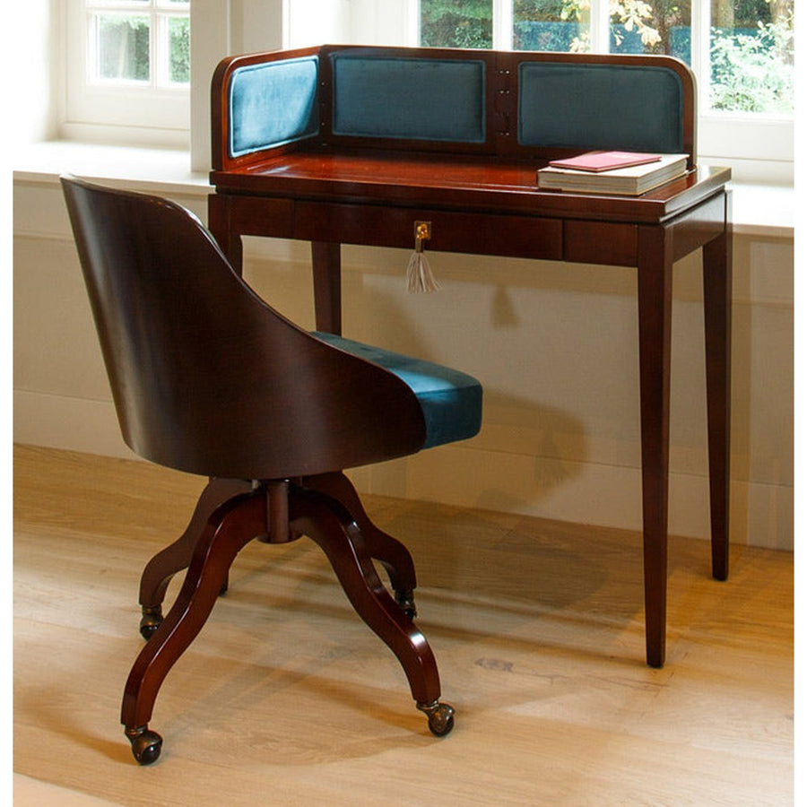 Hálószoba ablaka előtt álló bársonyberakásos panellel rendelkező íróasztal.