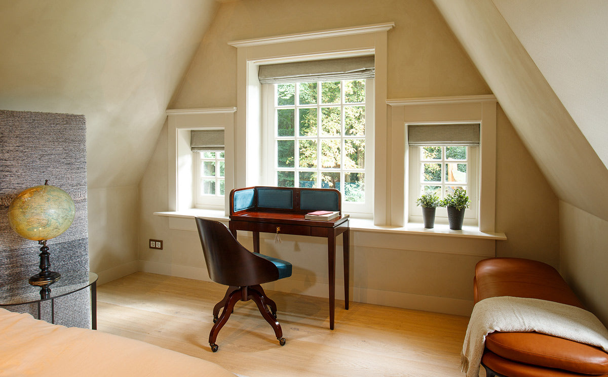 Hálószoba ablaka előtt álló bársonyberakásos panellel rendelkező íróasztal.