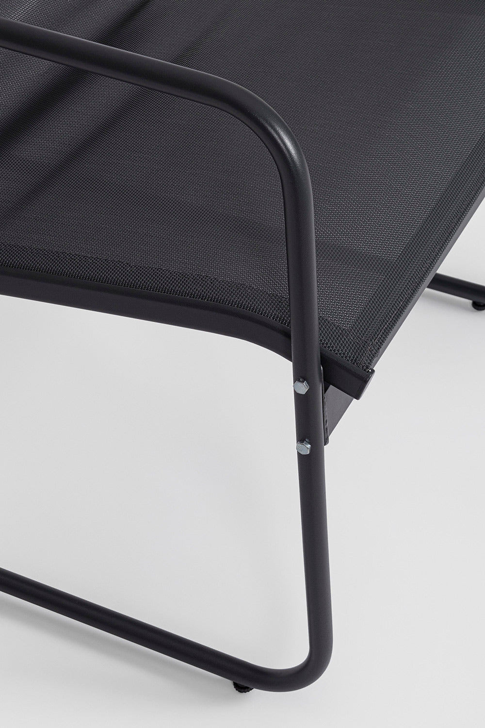 Kortárs stílusú, szénfekete színű fém kerti bútor szett székének részlete a textilén ülőfelületről.