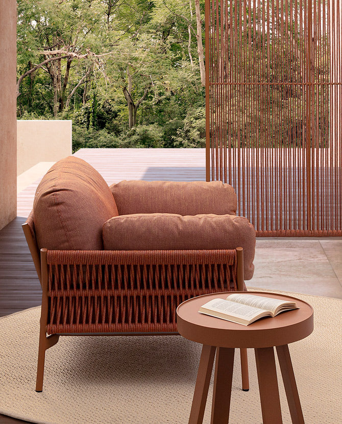 Fedett teraszon álló kortárs stílusú, korallszínű kültéri, kerti fotel.
